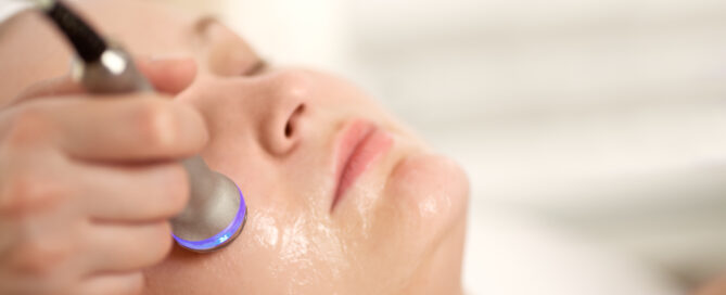 AlumierMD facial treatment being performed with a skin rejuvenation device.