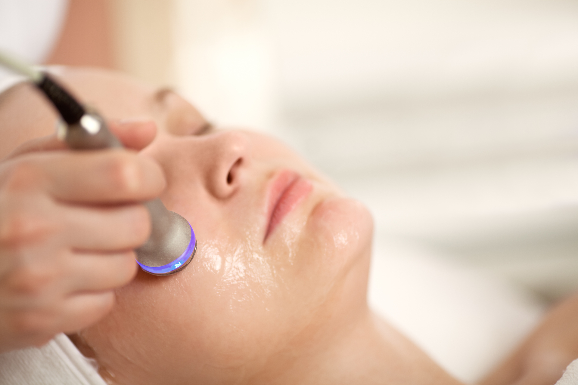 AlumierMD facial treatment being performed with a skin rejuvenation device.